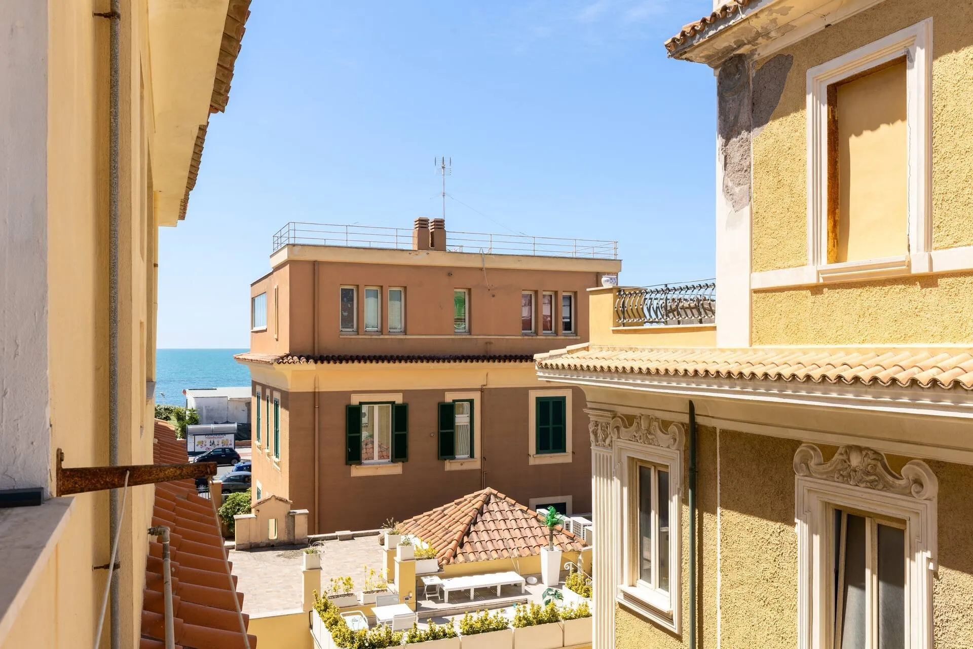 Vista dal balcone sulle case del quartiere, col mare in fondo a sinistra