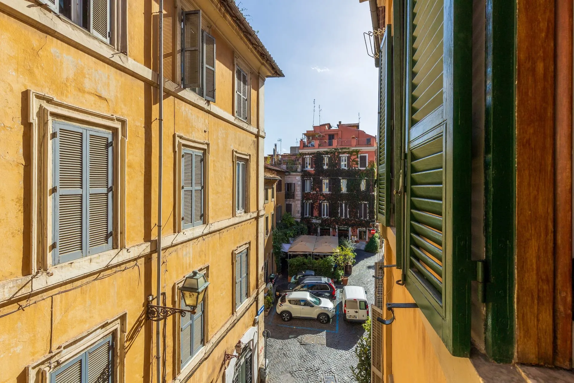 Vista dalla finestra sul vicolo, fra le facciate color ocra e le persiane verdi