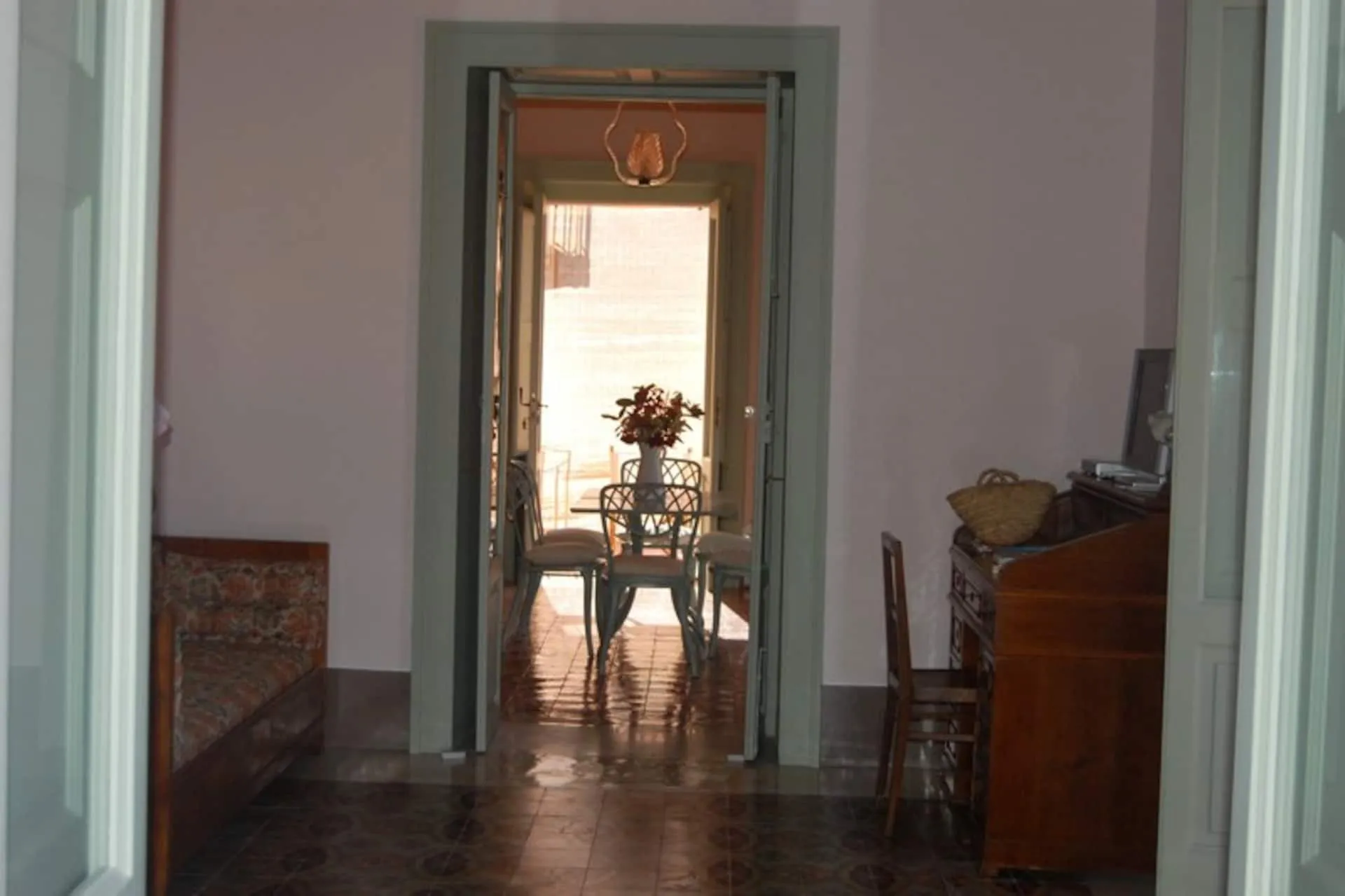 Infilata di stanze con porte verdi, fino alla sala da pranzo in fondo