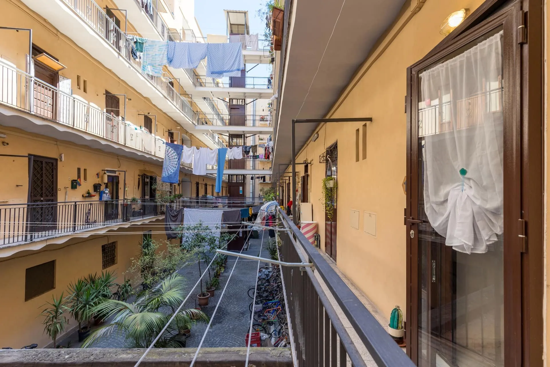 Ballatoio sul cortile interno, con le piante in basso e i panni stesi