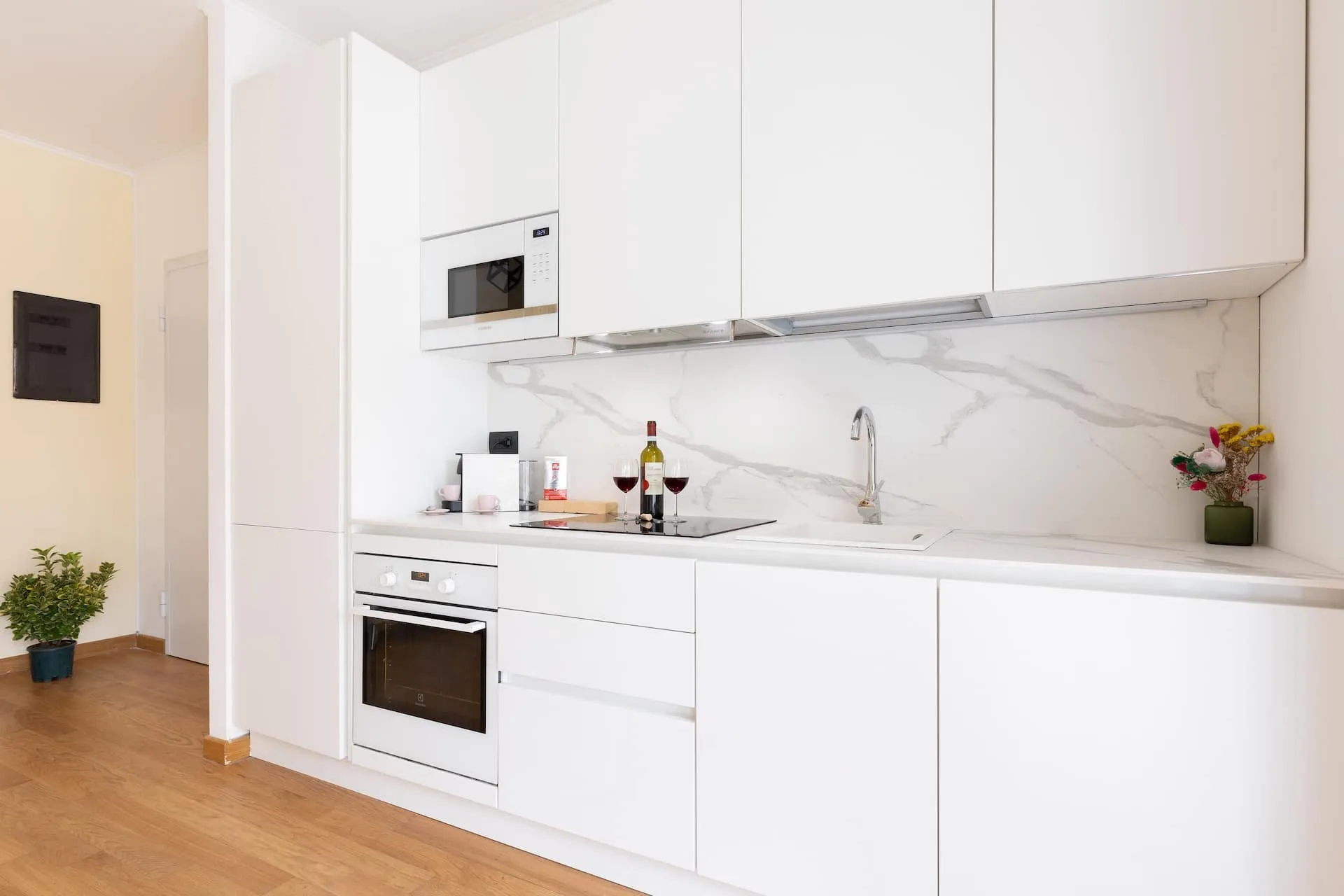 Cucina bianca con piano in marmo, forno e microonde a incasso