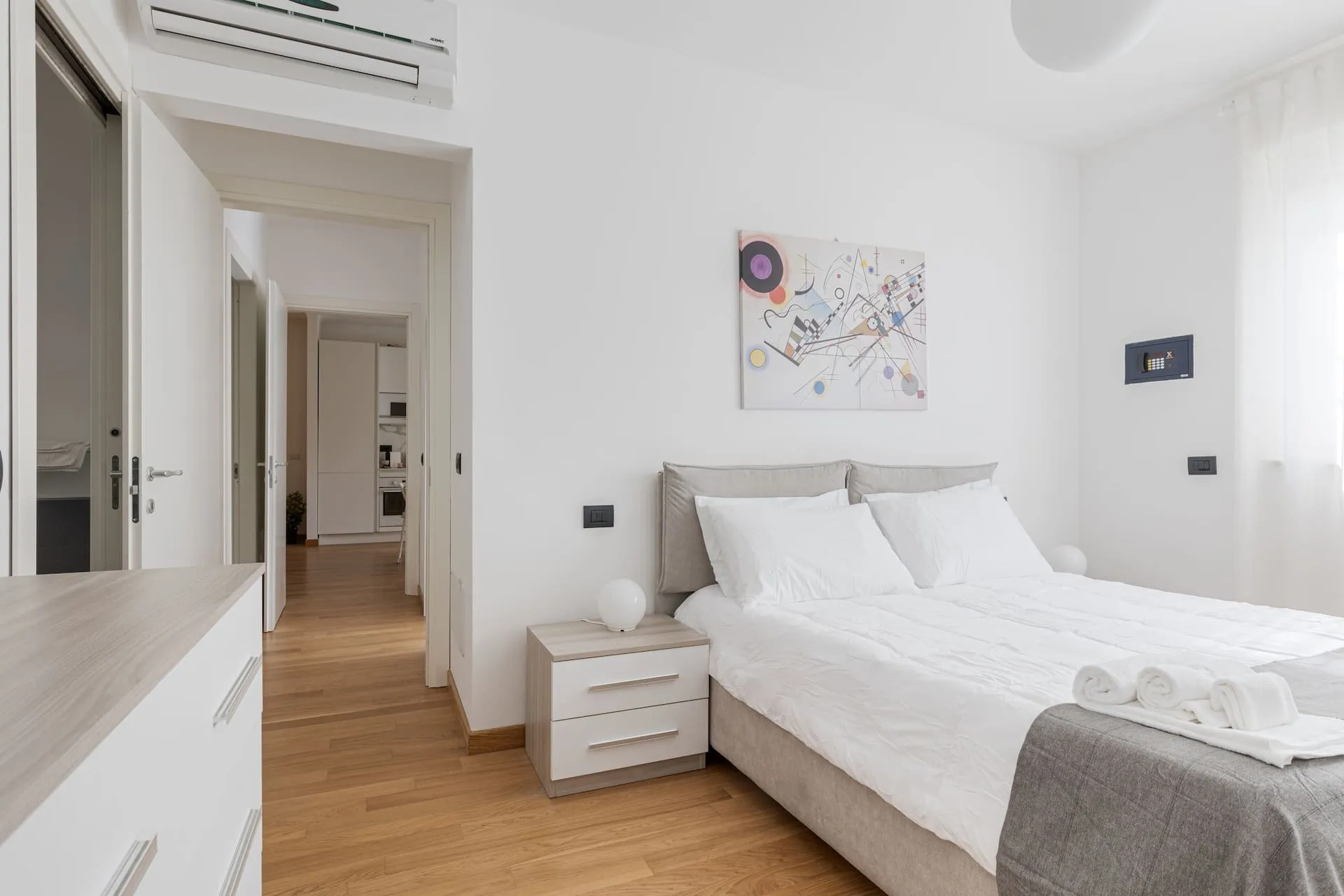 Seconda camera con letto matrimoniale, comodini e porta sul corridoio